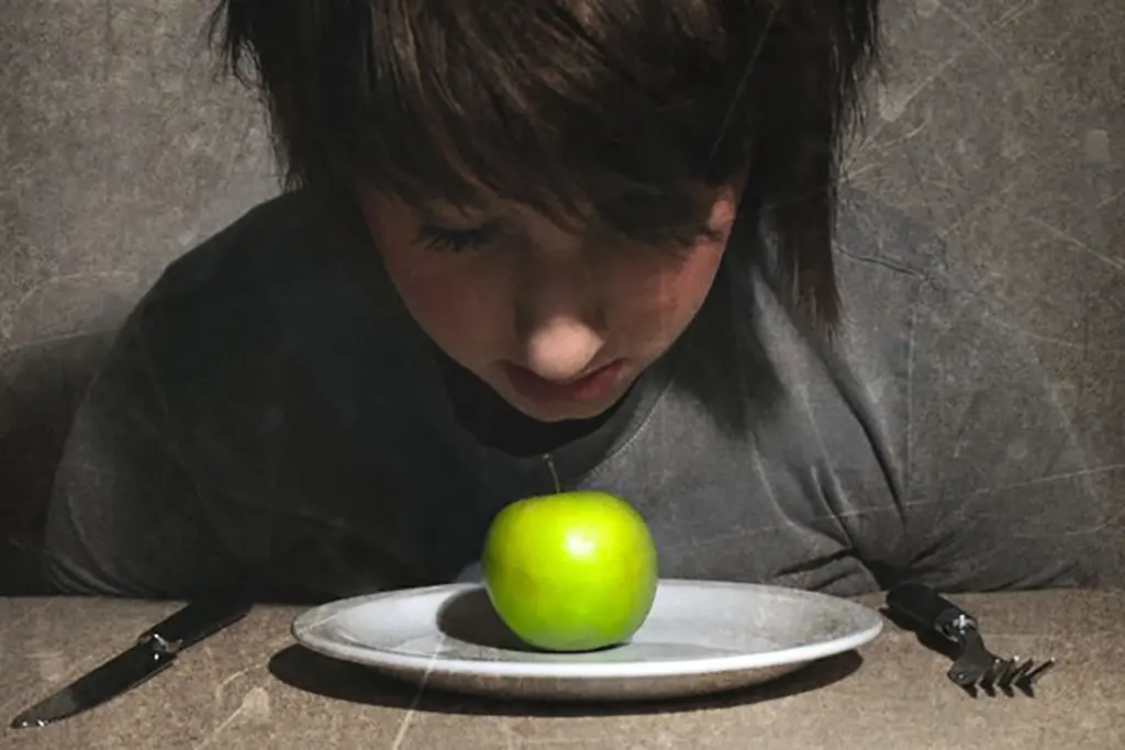 Anorexia. Persona comiendo manzana